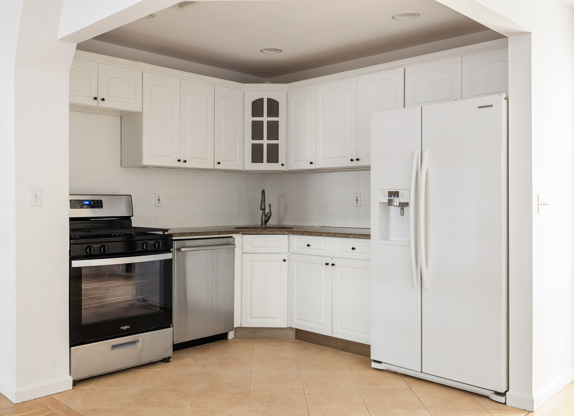 174 Patchen Avenue Brooklyn, NY 11221 - Photo 4 of 12 a kitchen with stainless steel appliances granite countertop white cabinets and window