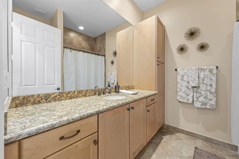 a bathroom with a granite countertop sink and a mirror