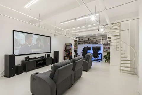 a living room with furniture a flat screen tv and gym equipment