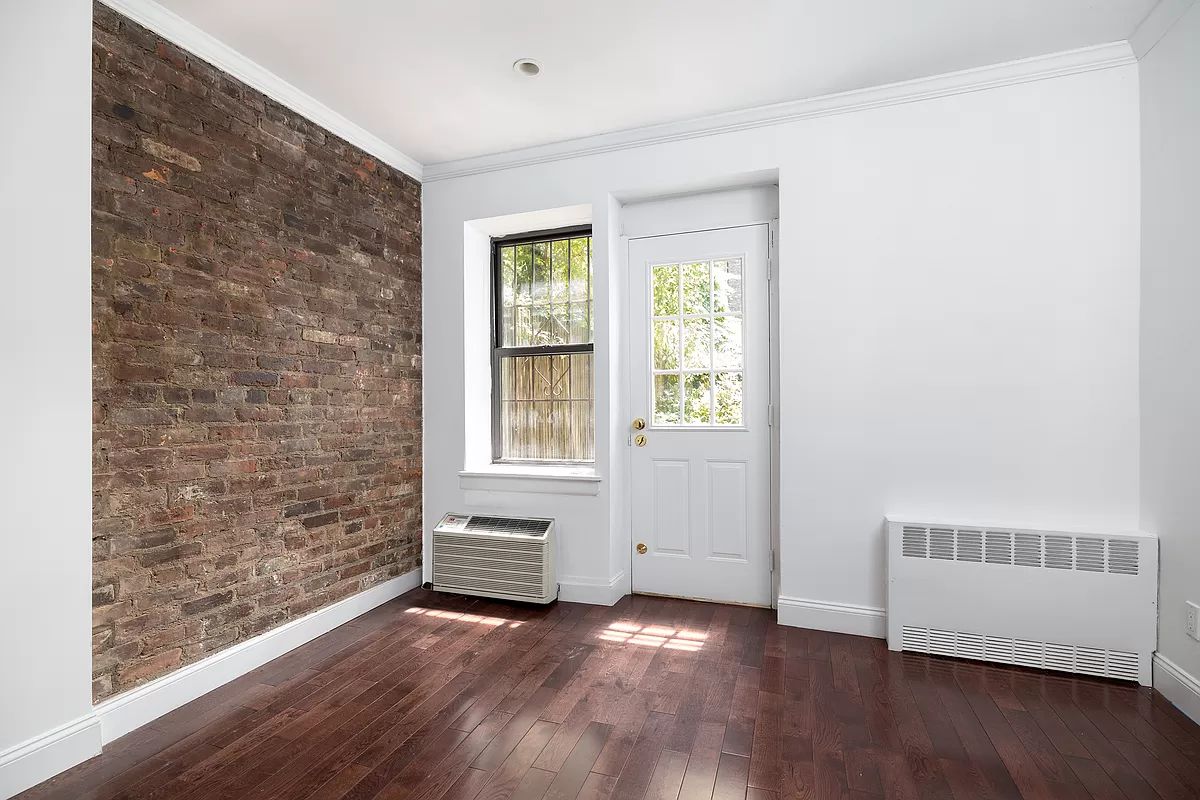 328 West 19th Street, Unit 1B Manhattan, NY 10011 - Photo 4 of 11 an empty room with wooden floor and windows