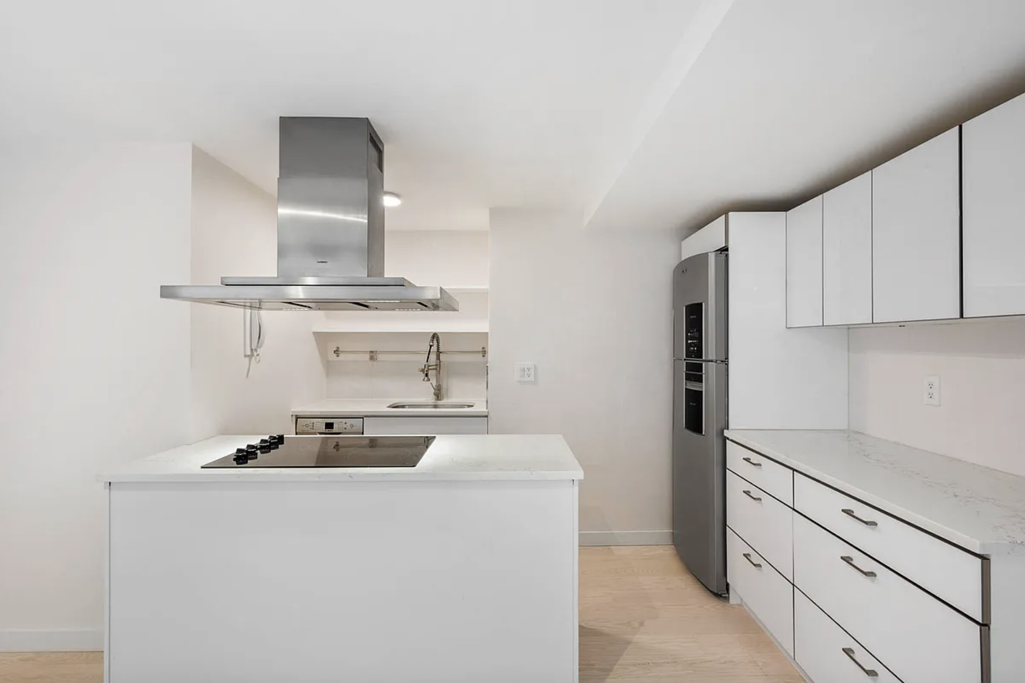 159 East 53rd Street, Unit 10A Manhattan, NY 10022 - Photo 3 of 10 a kitchen with stainless steel appliances a stove refrigerator and white cabinets