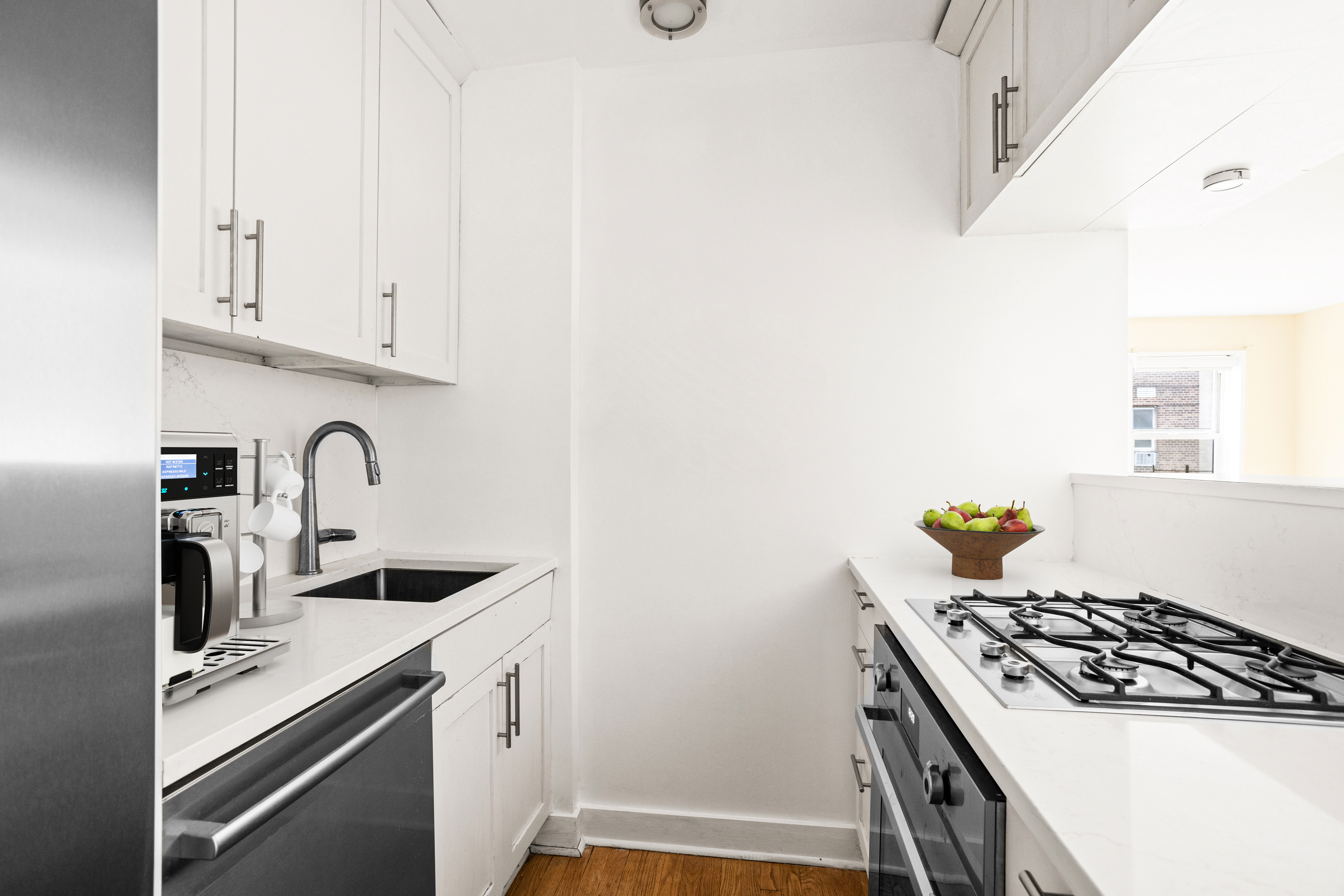 140 7th Avenue, Unit 7M Manhattan, NY 10011 - Photo 4 of 11 a kitchen with white cabinets and appliances