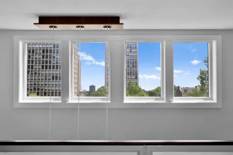 a kitchen with stainless steel appliances granite countertop a dining table chairs refrigerator and sink