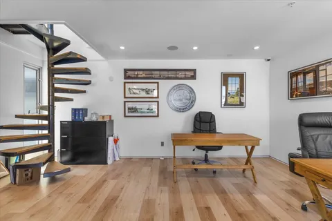 a view of a workspace with furniture and wooden floor