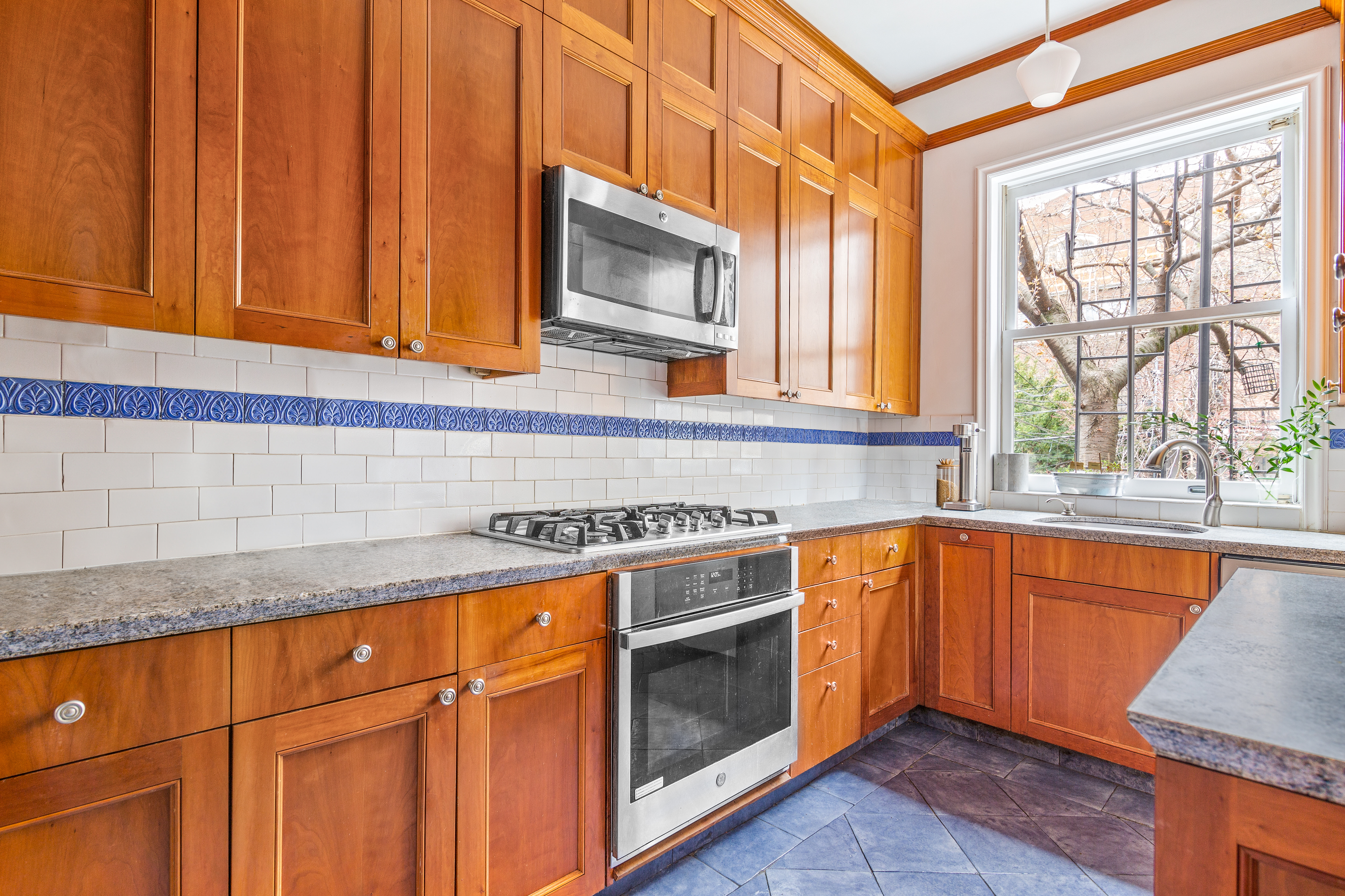 176 Warren Street Brooklyn, NY 11201 - Photo 3 of 13 a kitchen with stainless steel appliances granite countertop wooden cabinets a sink and a dishwasher next to a window
