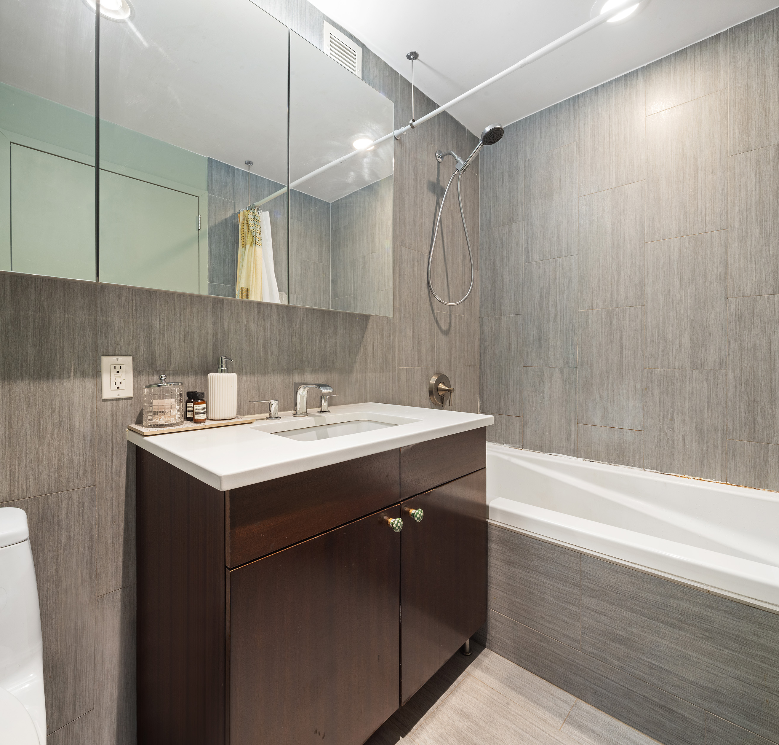 215 Avenue B, Unit 4A Manhattan, NY 10009 - Photo 7 of 13 a bathroom with a sink mirror and a bathtub