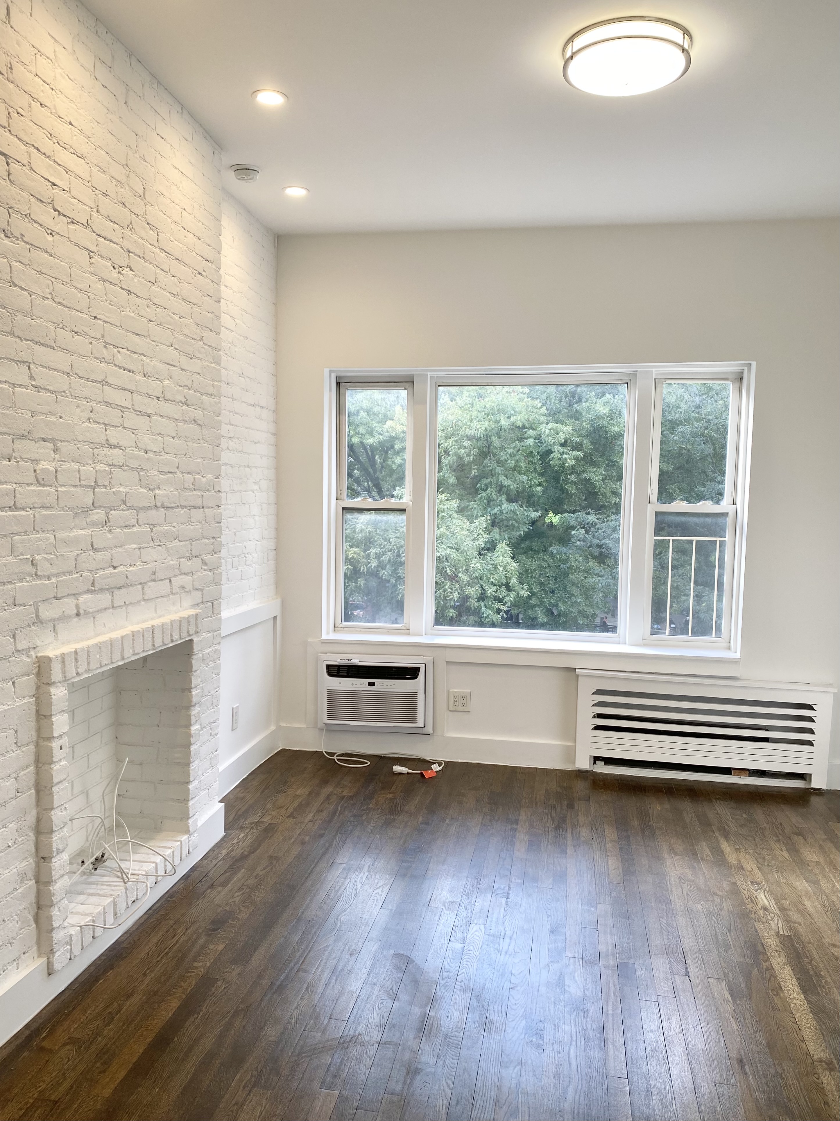 an empty room with wooden floor and a fireplace