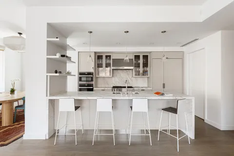 a kitchen with stainless steel appliances a table and chairs in it