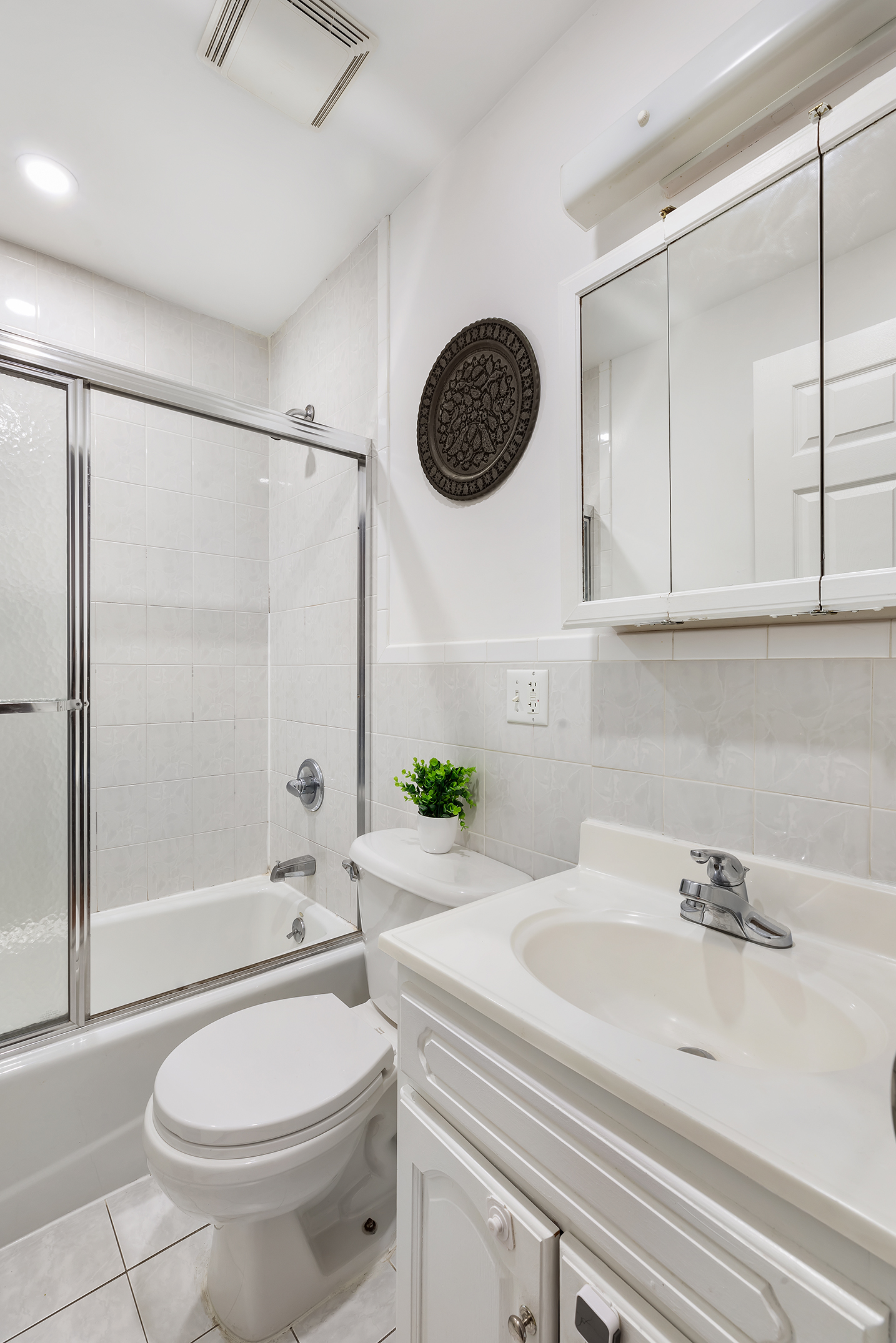 97 Moore Street, Unit 4B Brooklyn, NY 11206 - Photo 6 of 8 a bathroom with a sink a toilet and a mirror