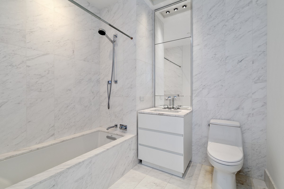111 Murray Street, Unit 16B Manhattan, NY 10007 - Photo 7 of 22 a bathroom with a sink toilet and shower