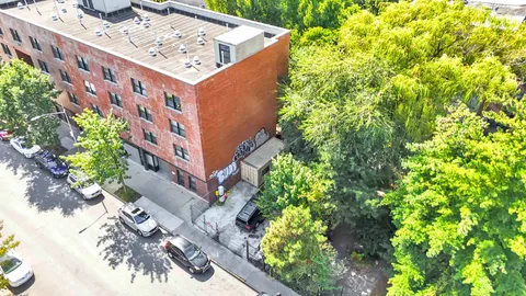 a view of a tall building with a tree in the background
