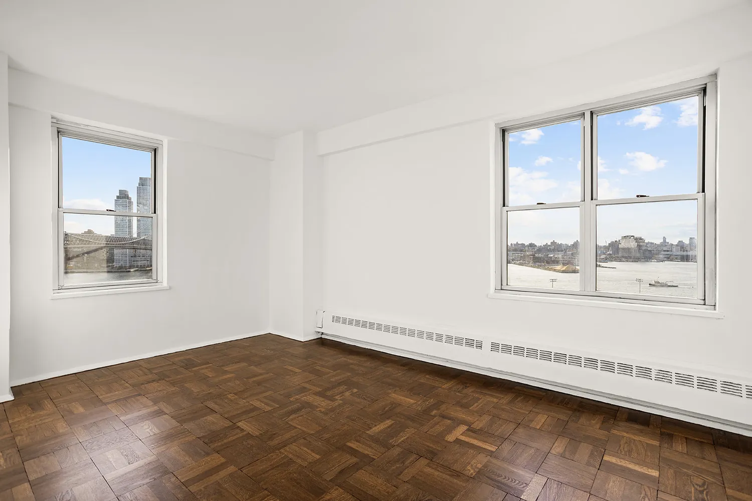 a view of a big room with wooden floor and windows