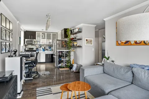 a living room with furniture and a kitchen view