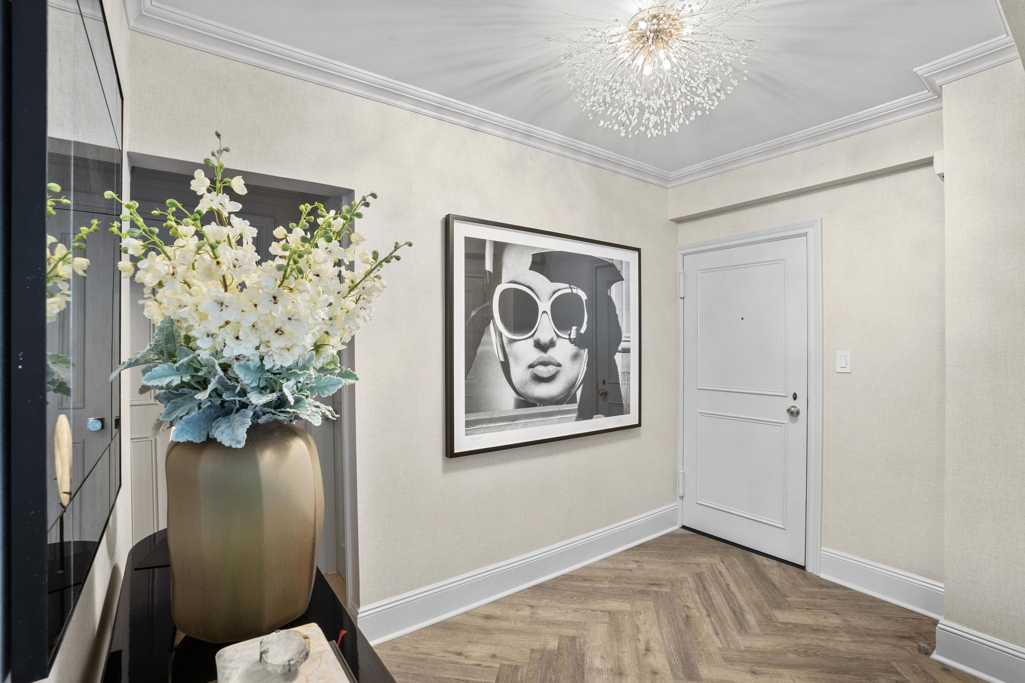 110 East 57th Street, Unit 10CD Manhattan, NY 10022 - Photo 4 of 16 a view of a hallway with wooden floor and a potted plant