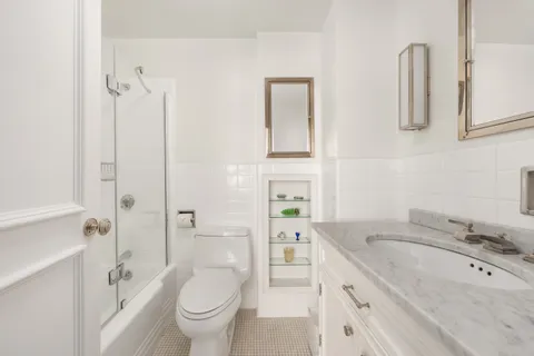 a bathroom with a granite countertop sink a toilet and shower