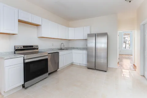 a kitchen with stainless steel appliances granite countertop a stove a sink and a refrigerator