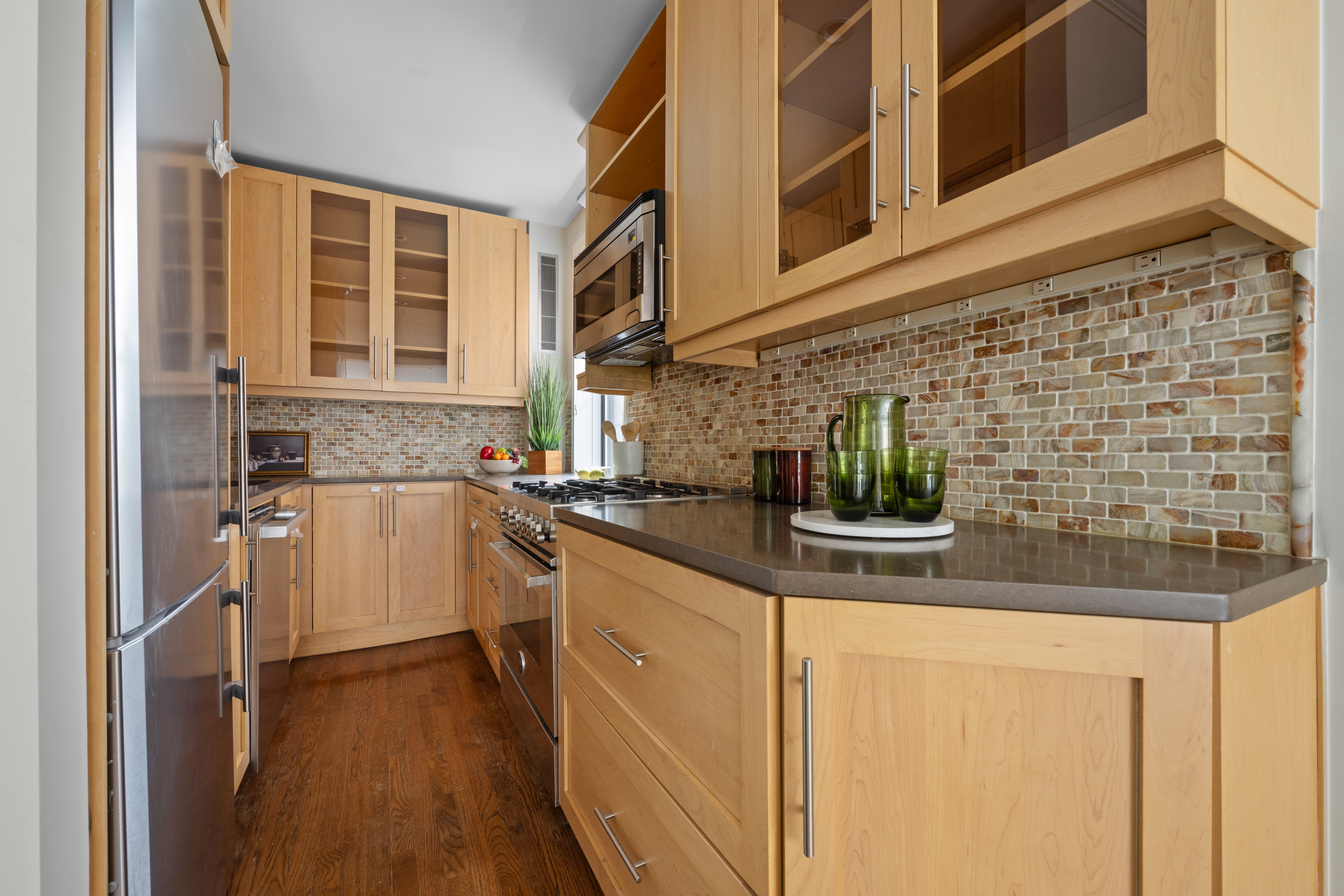 211 East 18th Street, Unit 2O Manhattan, NY 10003 - Photo 5 of 14 a kitchen with stainless steel appliances granite countertop a sink and cabinets