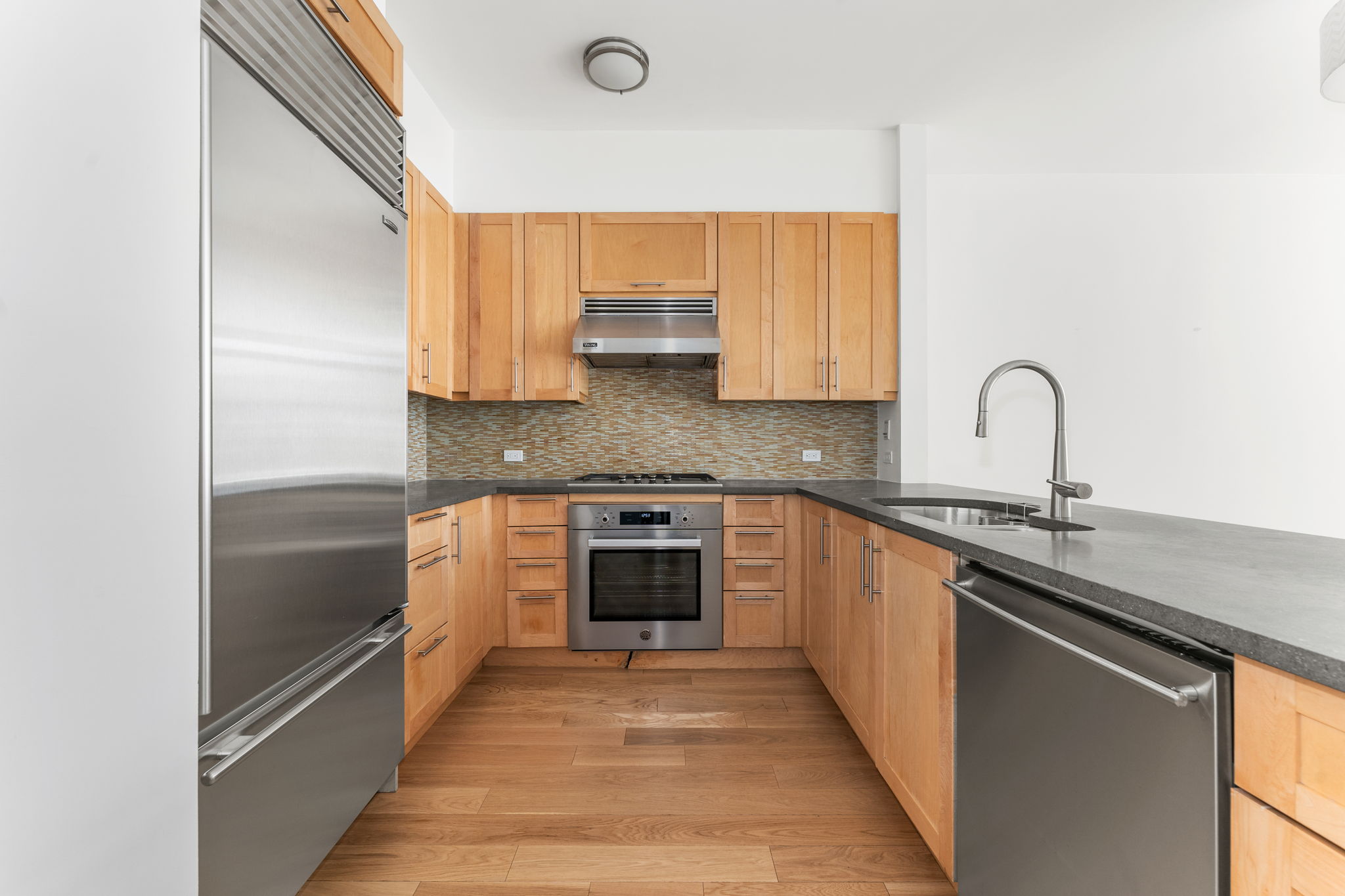545 West 110th Street, Unit 5A Manhattan, NY 10025 - Photo 3 of 20 a kitchen with stainless steel appliances granite countertop a sink and cabinets