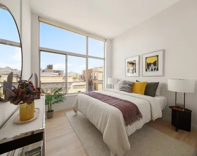 a bedroom with a bed and a large window