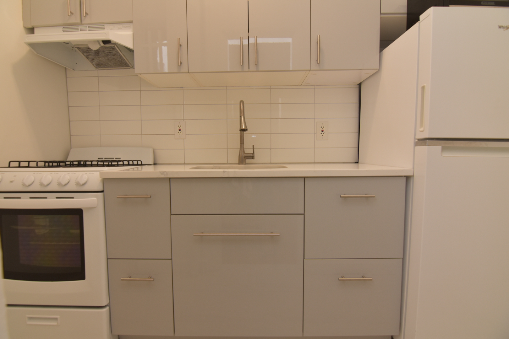 668 Riverside Drive, Unit 5A Manhattan, NY 10031 - Photo 6 of 8 a kitchen with white cabinets and white appliances
