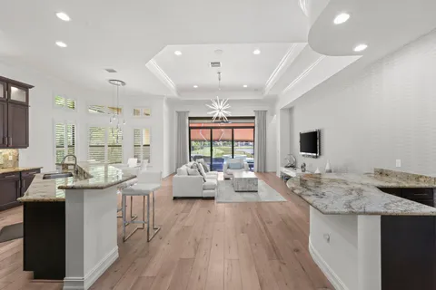 a very nice looking living room with a large window wooden floor and stainless steel appliances