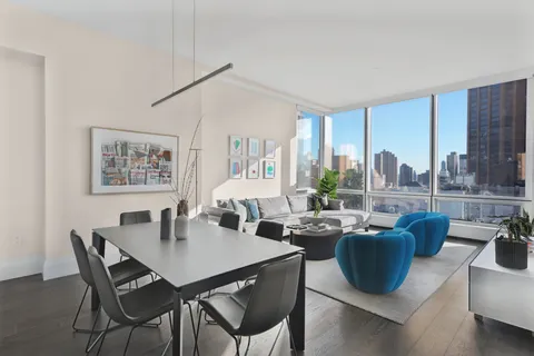 a view of a dining room with furniture large windows and wooden floor
