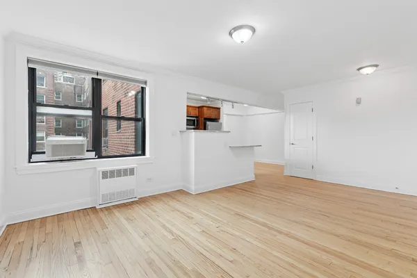 a view of empty room with wooden floor and windows