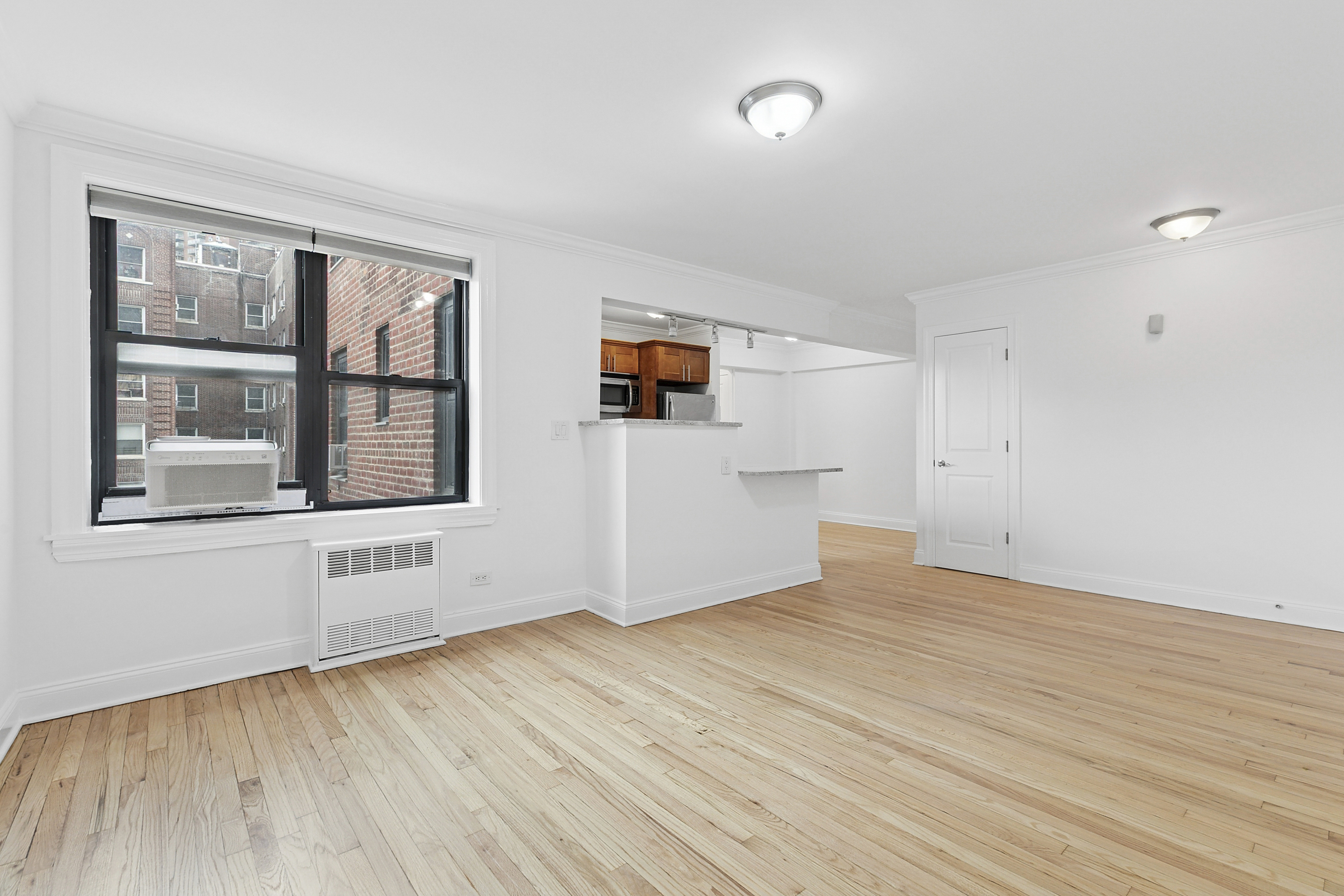 4501 Broadway, Unit 4G Manhattan, NY 10040 - Photo 1 of 7 a view of empty room with wooden floor and windows
