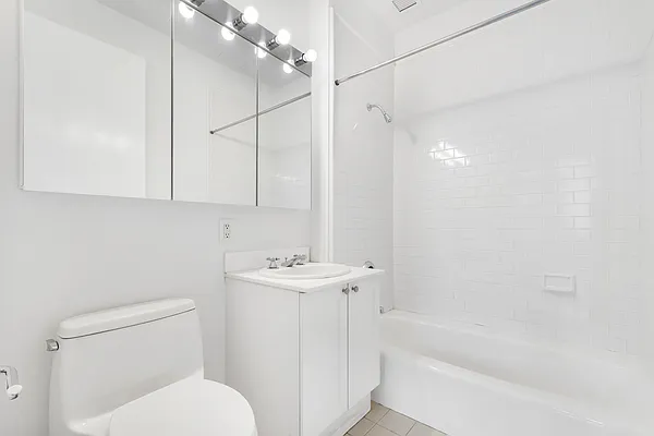 252 7th Avenue, Unit 10I Manhattan, NY 10001 - Photo 11 of 25 a bathroom with a toilet a sink and bathtub