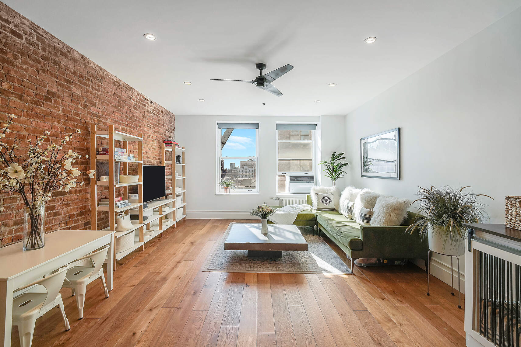 a living room with furniture flat screen tv and wooden floor