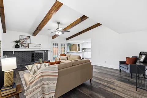 a view of an empty room with wooden floor and a fireplace