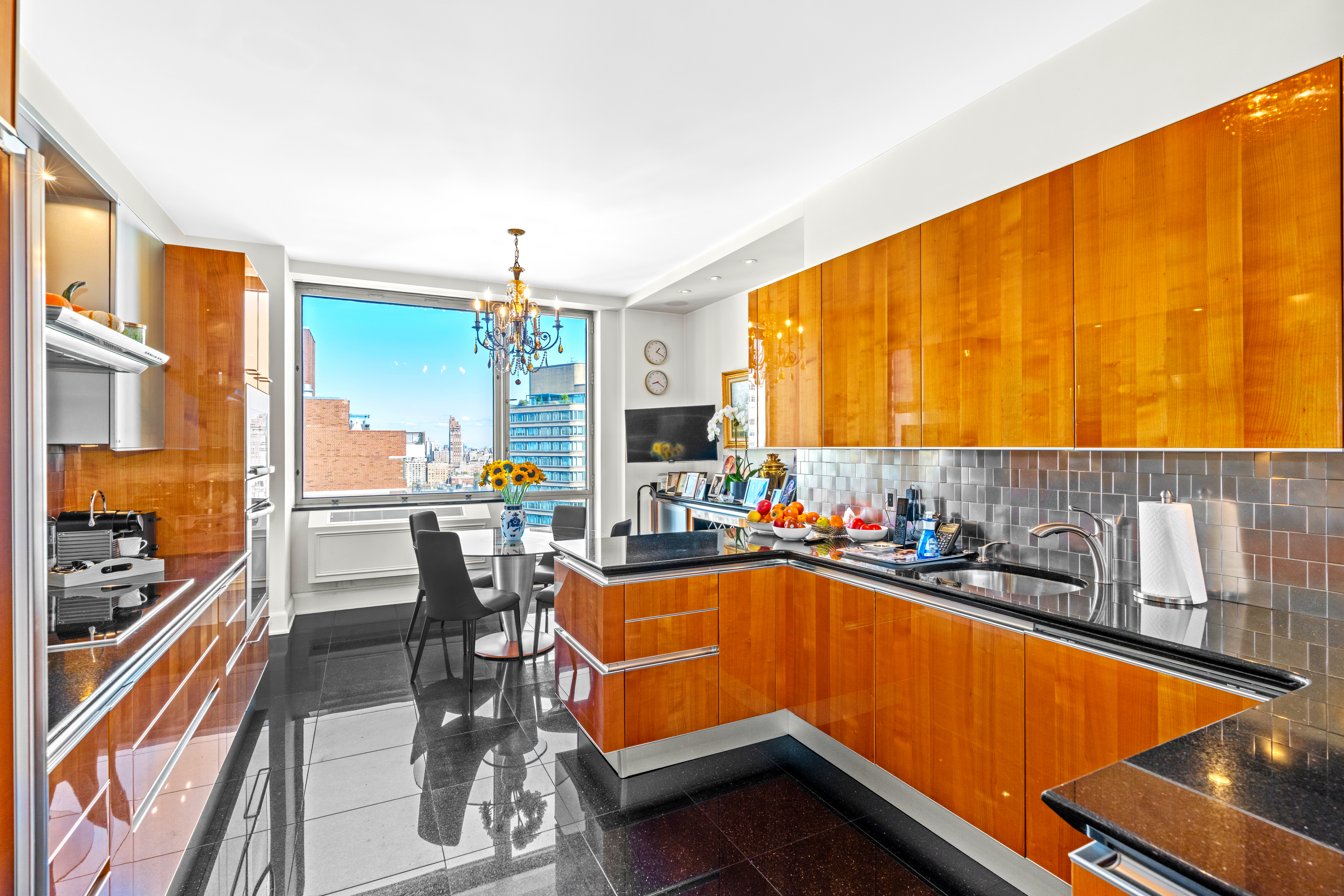 1965 Broadway, Unit 26EF Manhattan, NY 10023 - Photo 10 of 32 a kitchen with a sink and chairs