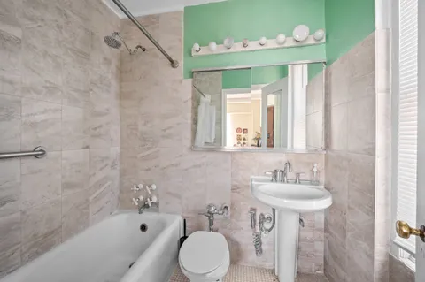 a bathroom with a sink mirror and a bathtub