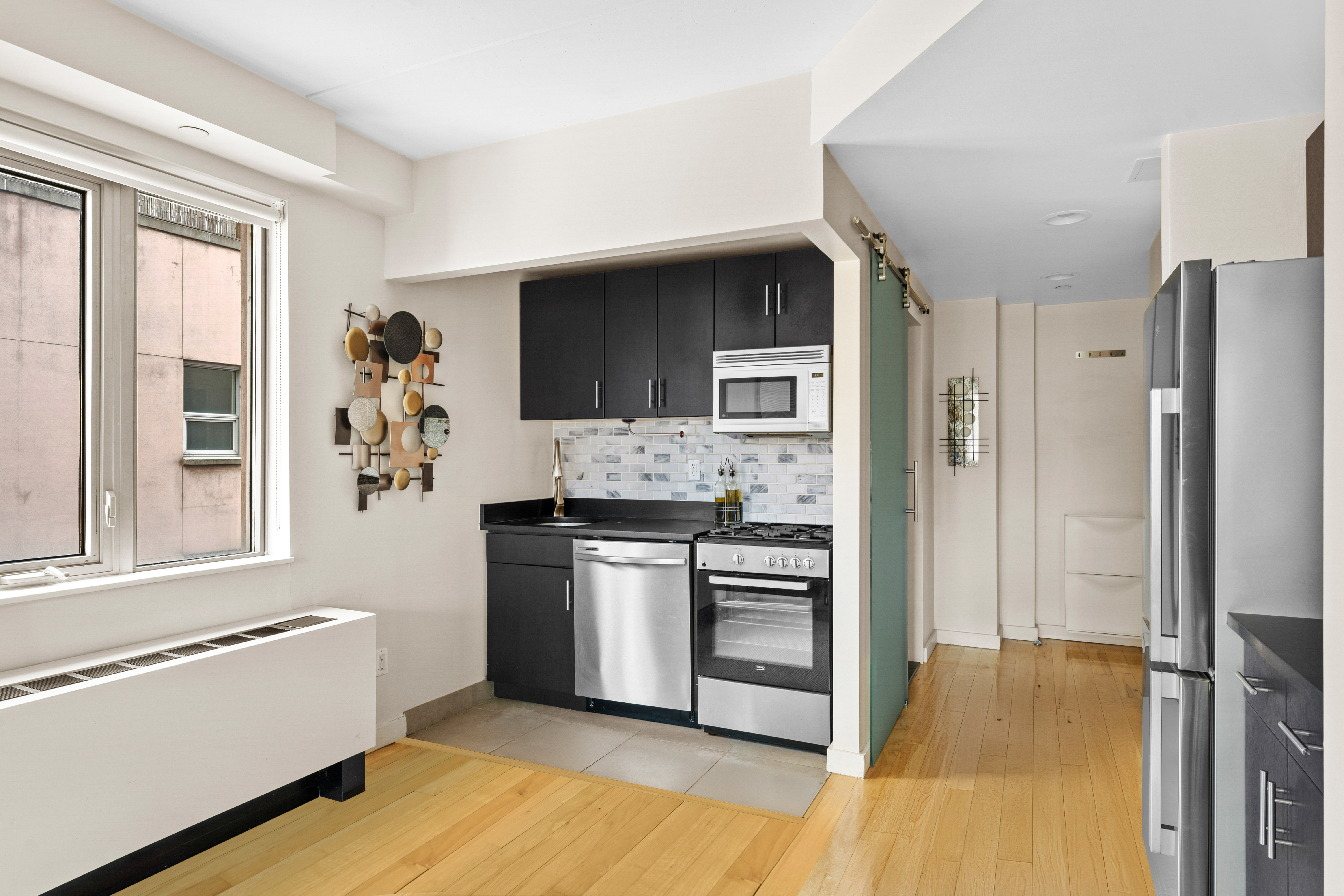 1810 3rd Avenue, Unit A9B Manhattan, NY 10029 - Photo 6 of 16 a kitchen with stainless steel appliances granite countertop a refrigerator and a stove top oven