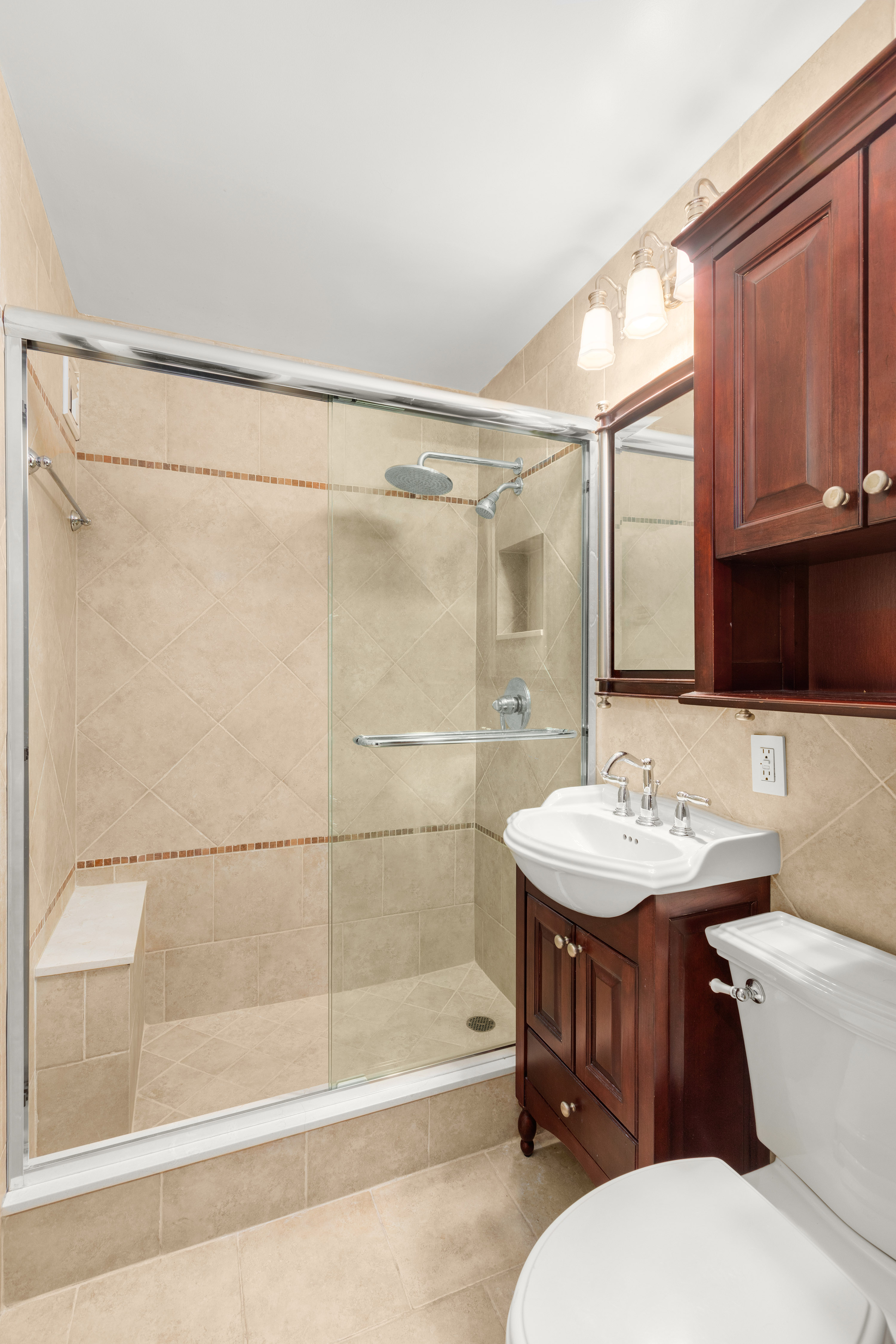 185 West End Avenue, Unit 24H Manhattan, NY 10023 - Photo 6 of 10 a bathroom with a sink toilet and shower