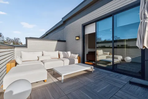 a backyard of a house with barbeque oven table and chairs