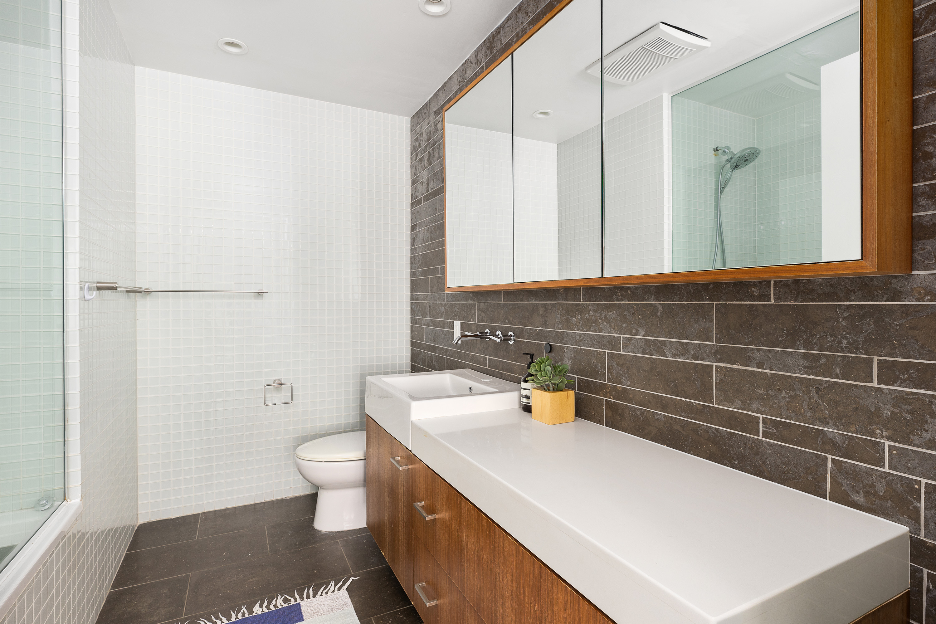 263 Bowery, Unit 5 Manhattan, NY 10002 - Photo 7 of 12 a bathroom with a sink a toilet and a mirror