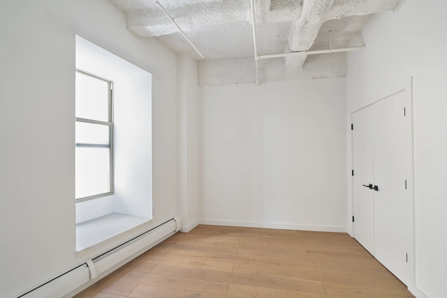 an empty room with windows and closet