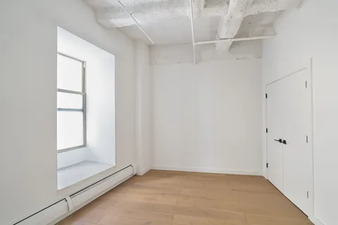 an empty room with windows and closet