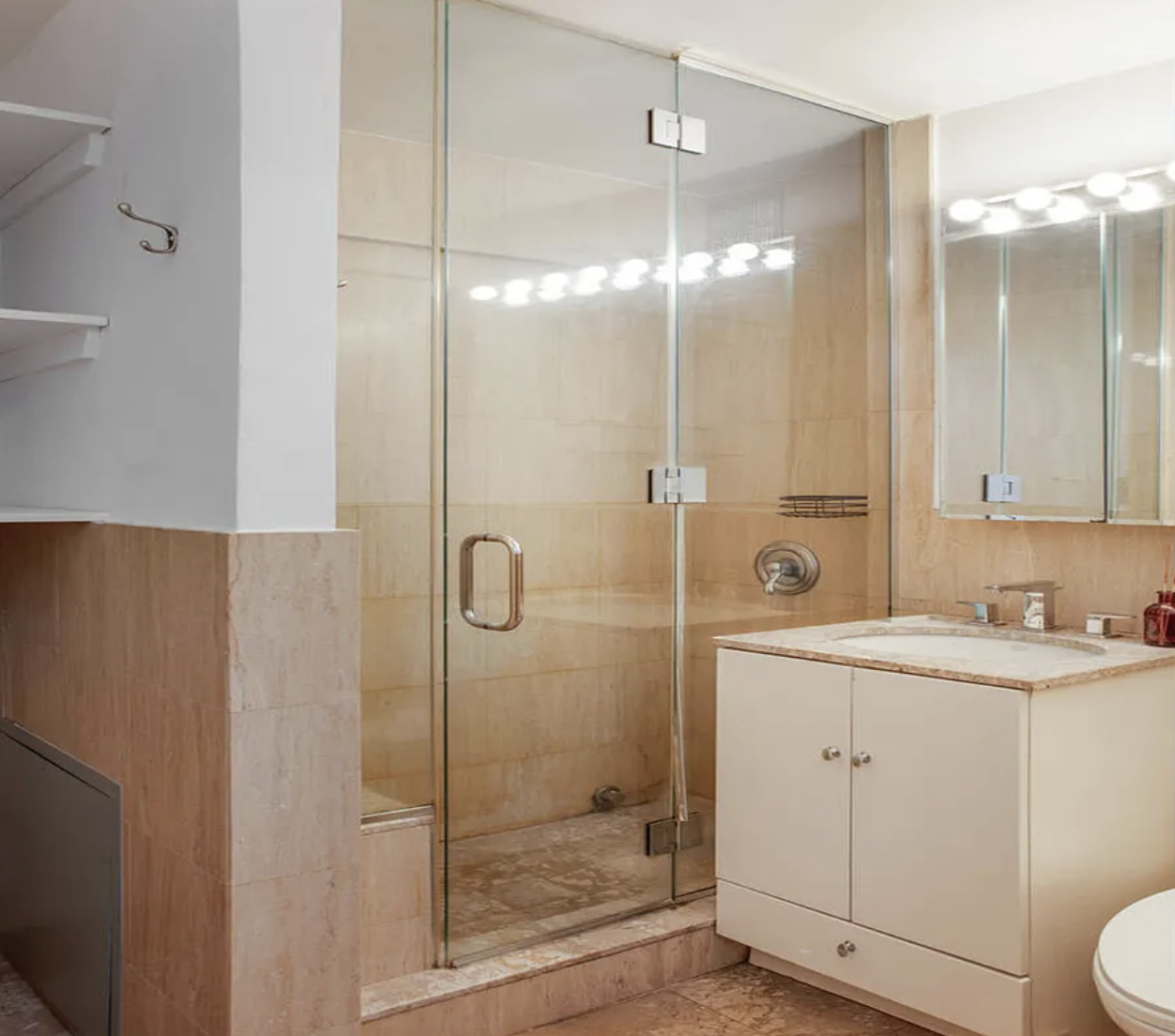 420 East 64th Street, Unit E7K Manhattan, NY 10065 - Photo 6 of 10 a bathroom with a shower a sink a toilet and mirror