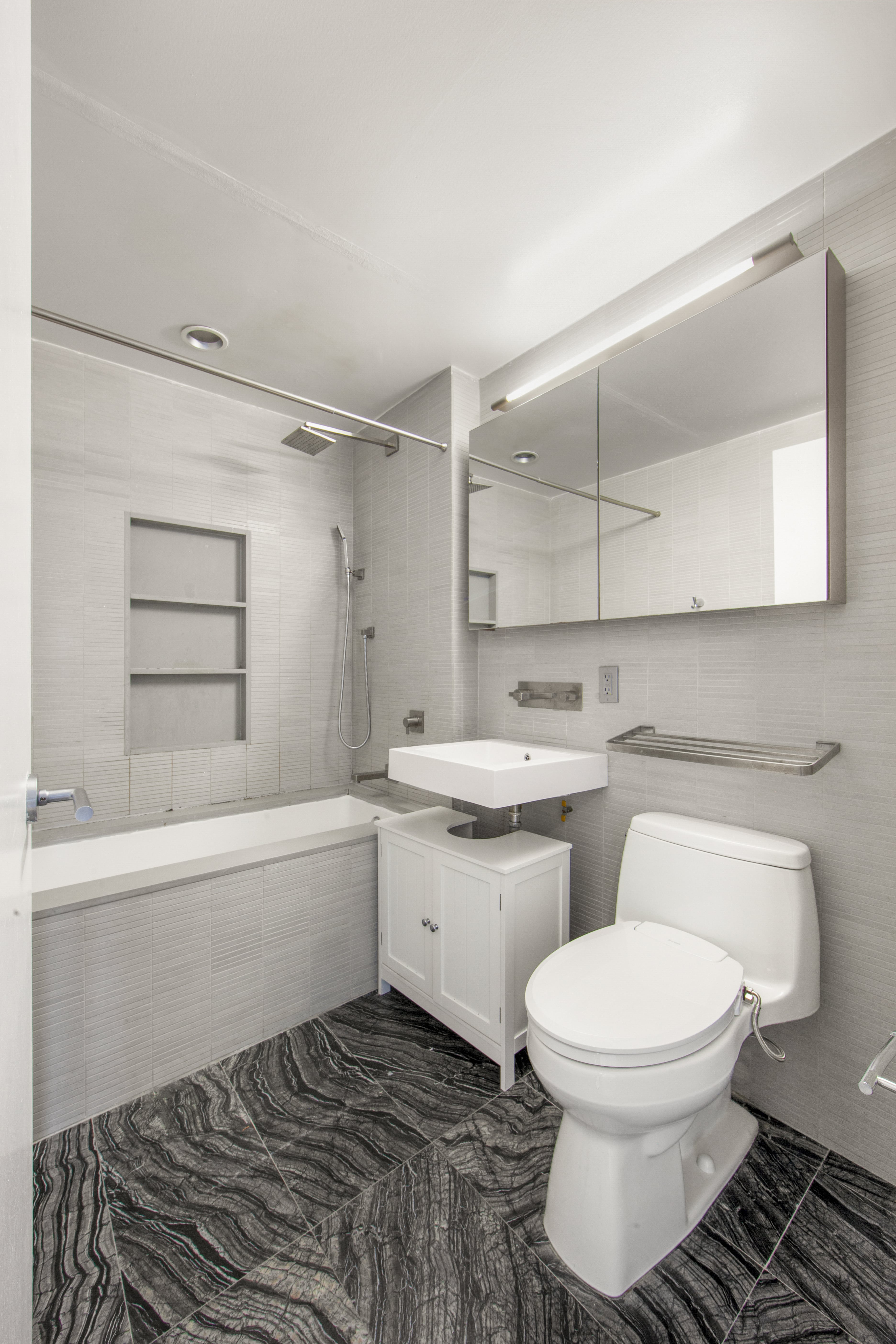 250 Bedford Avenue, Unit 129203 Brooklyn, NY 11249 - Photo 8 of 8 a bathroom with a toilet sink and bathtub