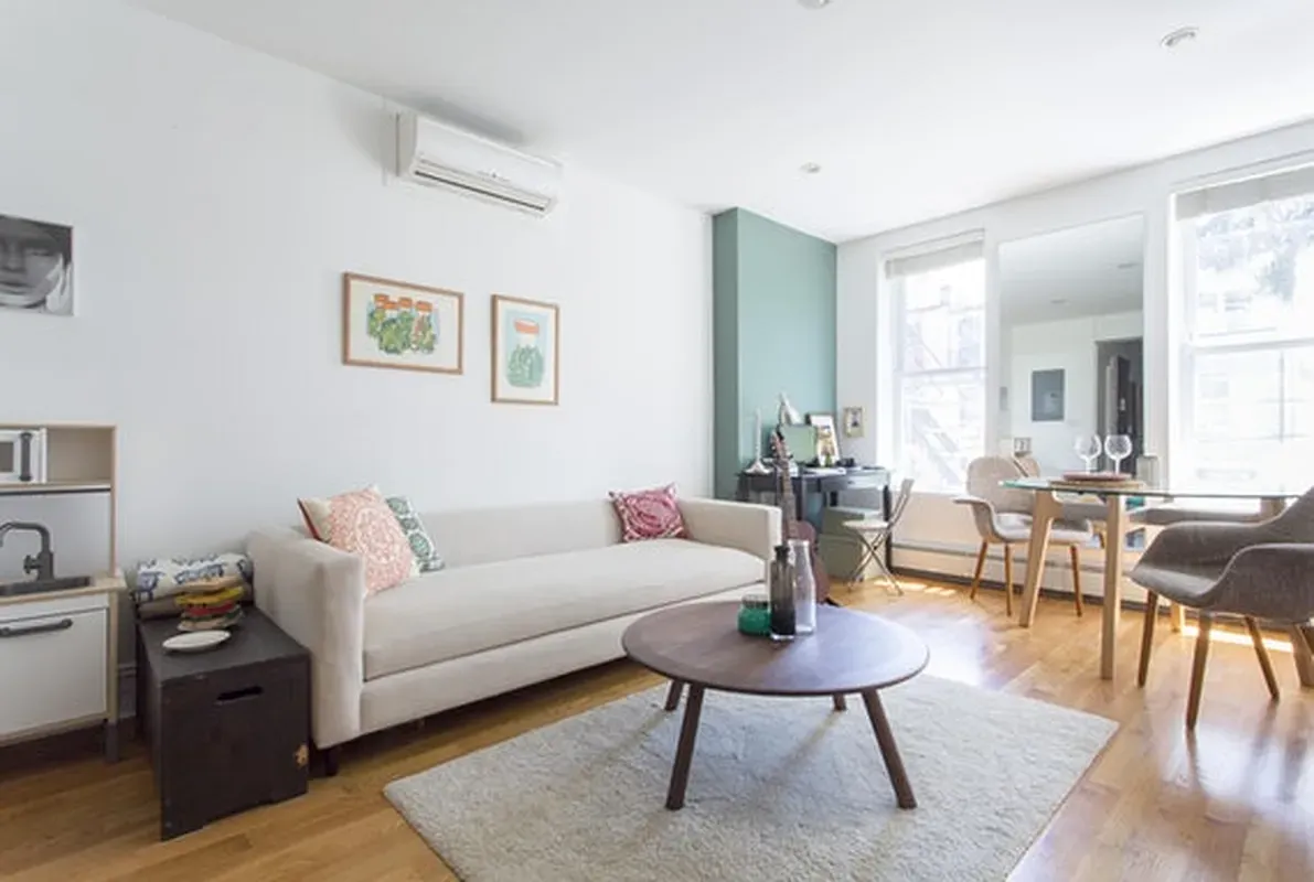a living room with furniture a rug and a table