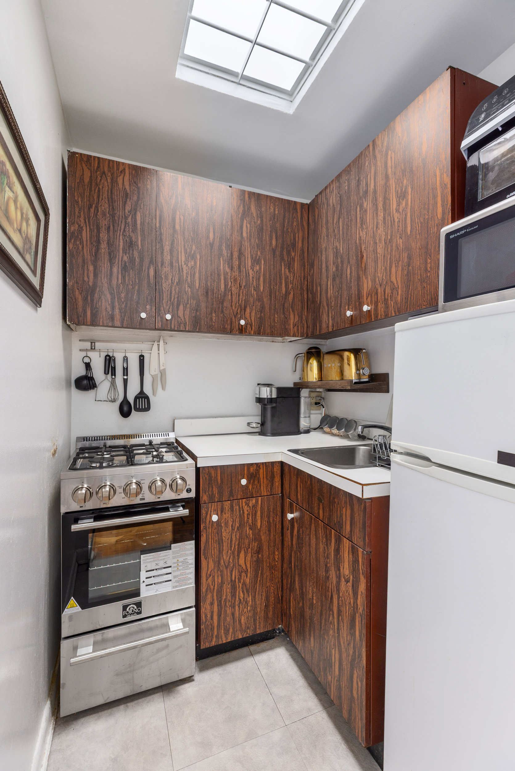 430 East 77th Street, Unit 7C Manhattan, NY 10075 - Photo 4 of 7 a kitchen with a stove a sink and a refrigerator