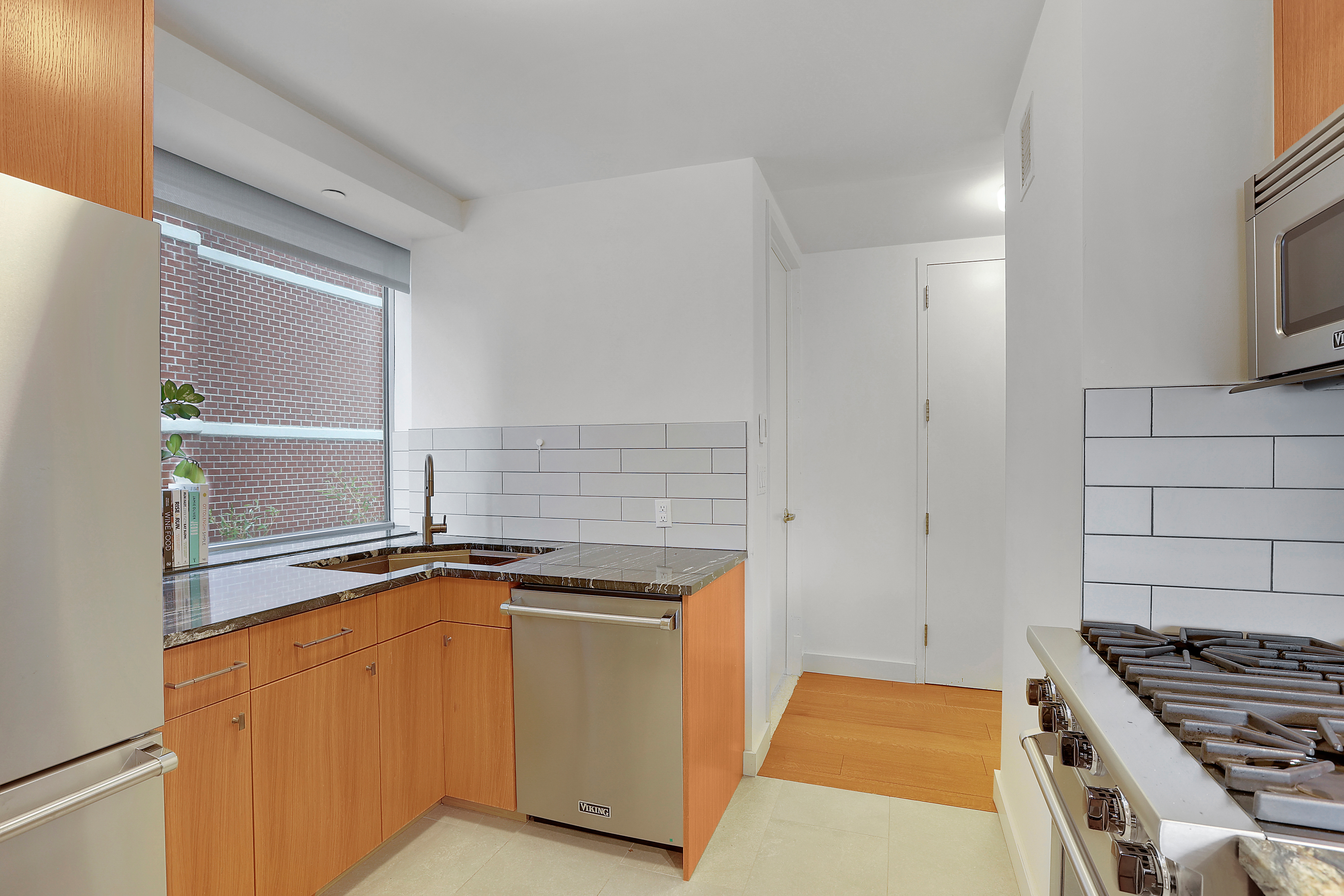1965 Broadway, Unit 14H Manhattan, NY 10023 - Photo 7 of 10 a kitchen with granite countertop a sink stove and cabinets