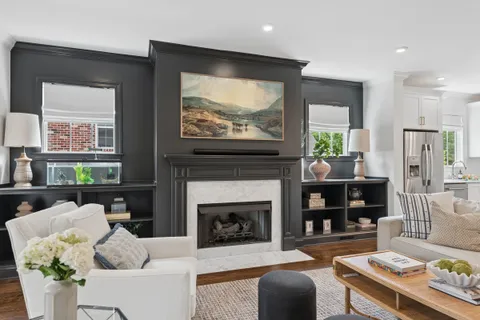 a living room with furniture a large window and a fireplace