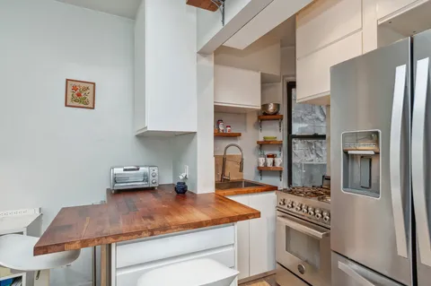 a kitchen with stainless steel appliances granite countertop a refrigerator and a stove