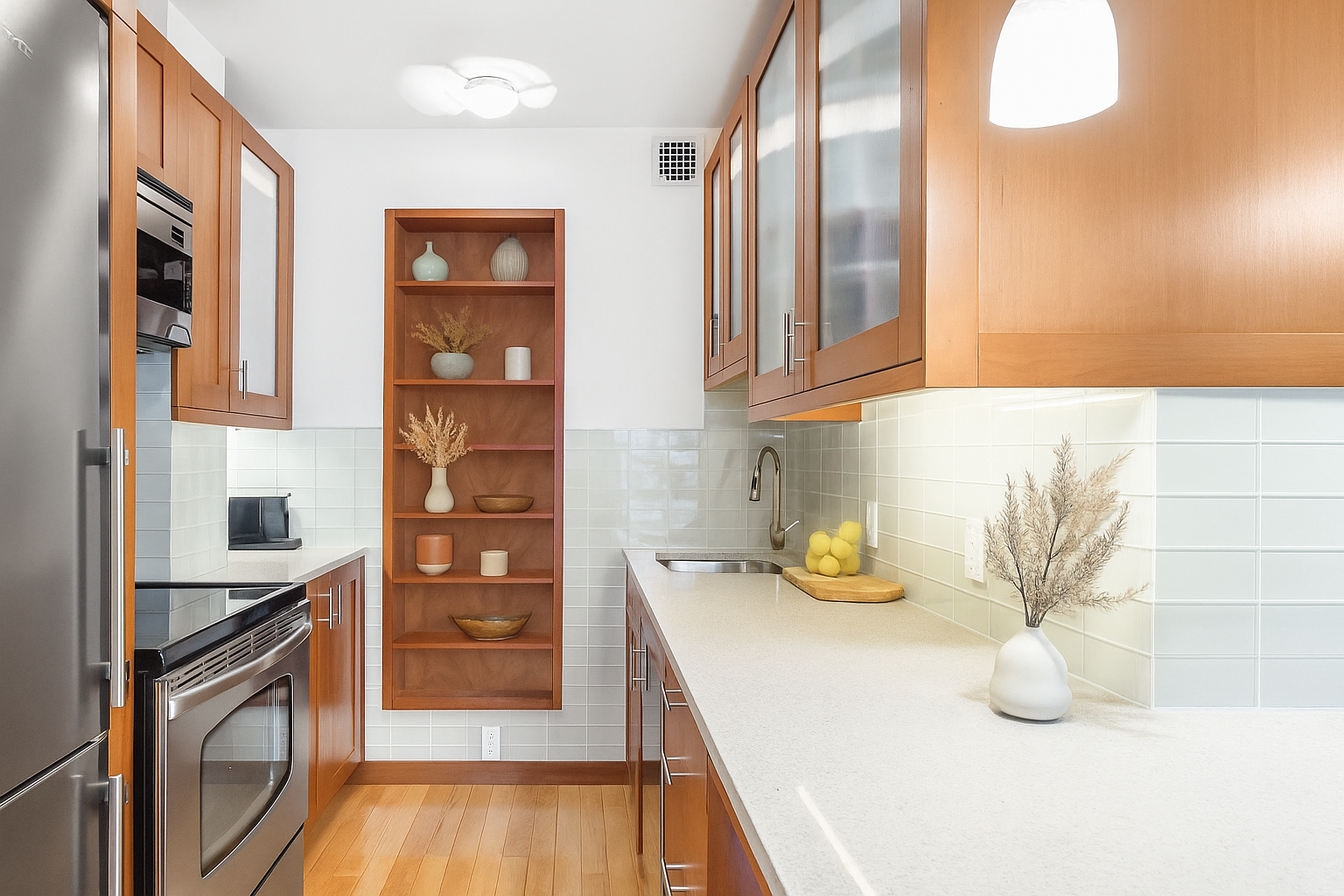 23 East 10th Street, Unit 231 Manhattan, NY 10003 - Photo 3 of 9 a kitchen with stainless steel appliances granite countertop a sink and wooden cabinets