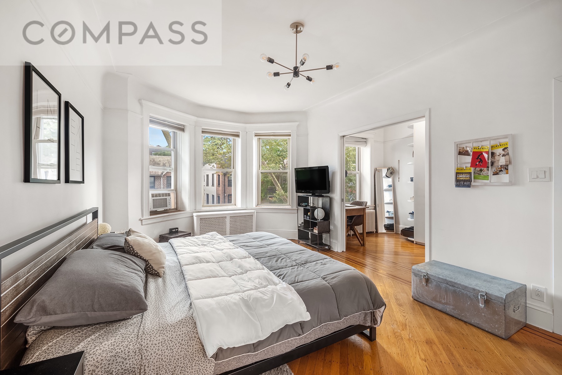 69 Sterling Street Brooklyn, NY 11225 - Photo 6 of 14 a bedroom with a bed and a flat screen tv