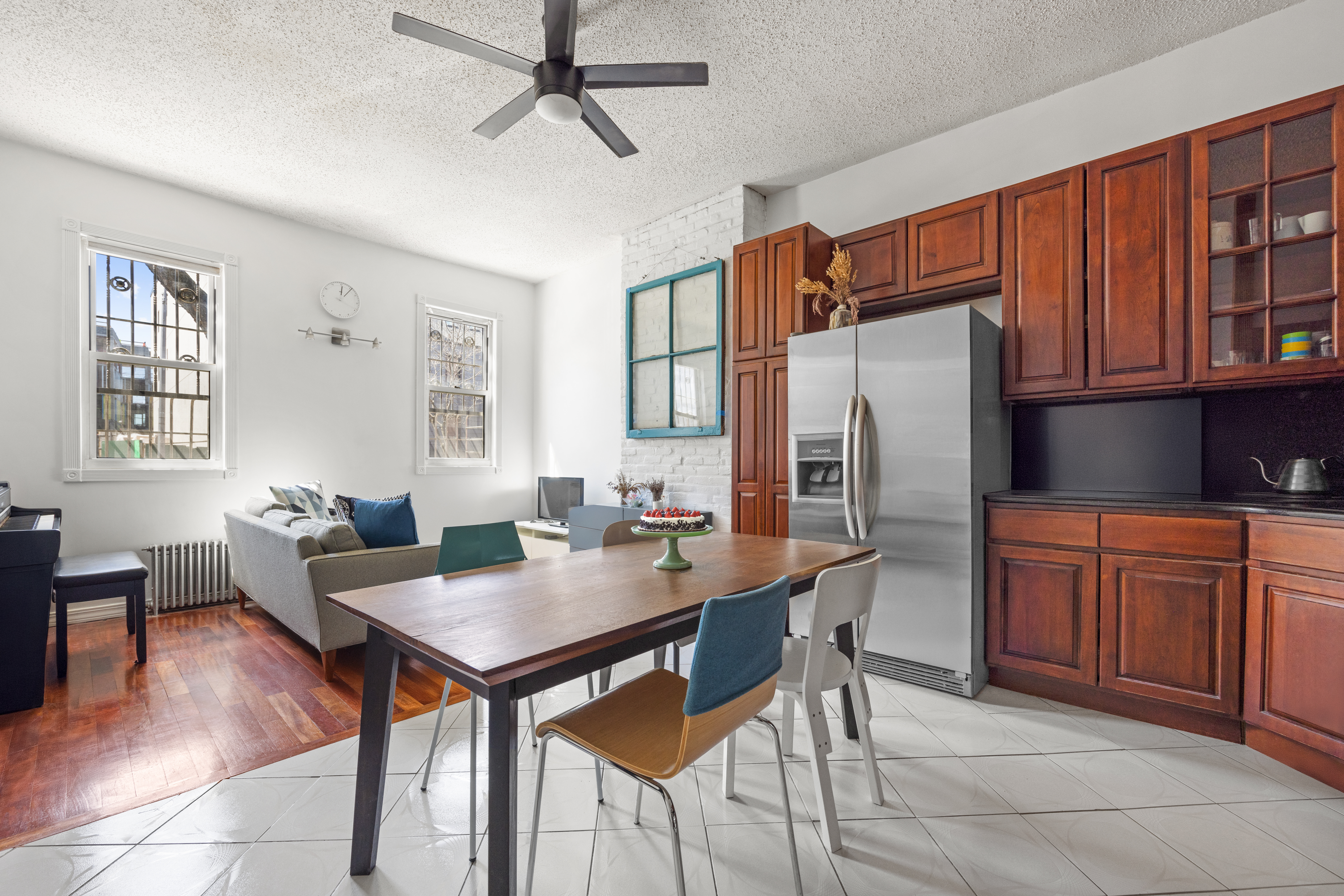 a dining room with stainless steel appliances granite countertop a refrigerator table and chairs