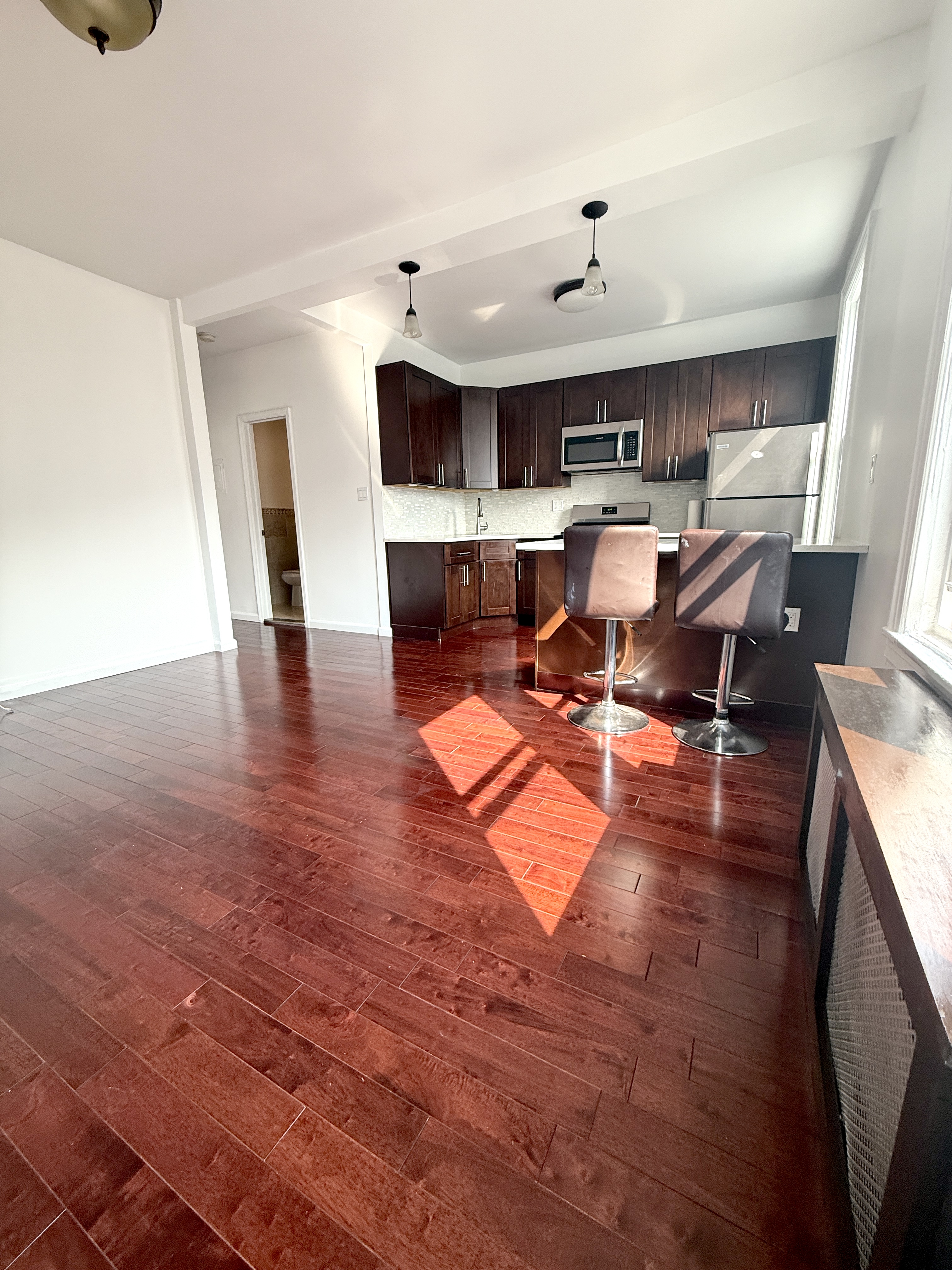 18-48 21st Drive, Unit 2R Queens, NY 11105 - Photo 5 of 7 a living room with furniture and a fireplace